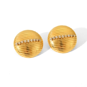 Close-up of gold disc stud earrings featuring horizontal ridges and pavé crystal accents