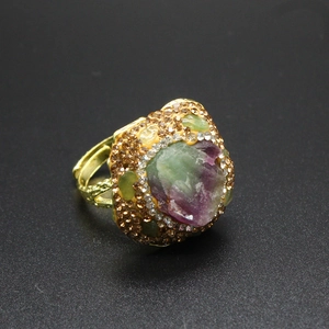 Close-up of vintage gold ring with raw purple gemstone and pavé-set brown diamonds