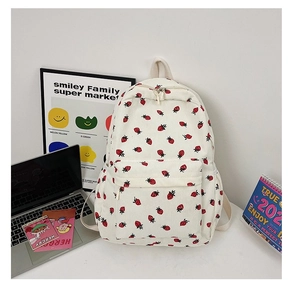Close-up of cream corduroy backpack featuring red strawberry prints and soft texture