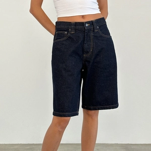 Detail shot of slim-fit dark blue denim Bermuda shorts for women with straight-leg cut