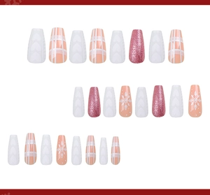 Macro detail of coffin press-on nails featuring glitter, snowflake prints and heart relief