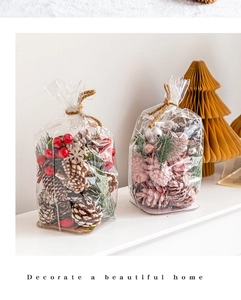 Gros plan de pommes de pin décoratives avec baies rouges et boules argentées en sachets