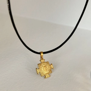 Detail showing 18k gold-plated Saint Benedict cross medallion with black cord