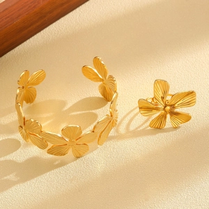 Macro shot of gold floral jewelry set with detailed matte brushed metal texture