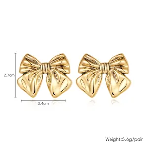 Detailed view of gold bow earrings showing dimensions of 3.4cm by 2.7cm and 5.6g weight