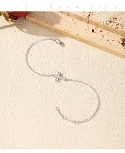 Macro detail of S925 sterling silver cross bracelet with Moissanite stones and lobster clasp