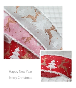 Macro detail of linen Christmas ribbons with glitter elk and white fringe edges