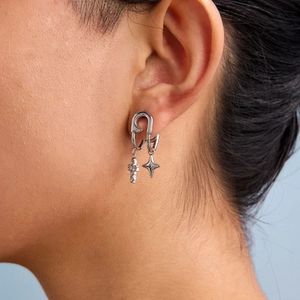 Silver paperclip earring with cross and star charms on model, minimalist stainless steel