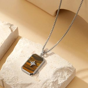 Close-up of silver rectangle tiger eye pendant with a hexagram star on beige stone