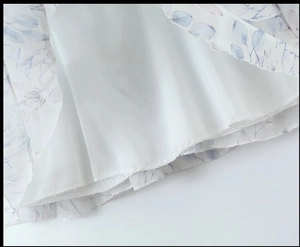Détail du tissu en mousseline à fleurs bleues avec une doublure intérieure blanche