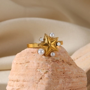 Detailed macro shot of a gold star ring with pearls and diamonds on a rock surface