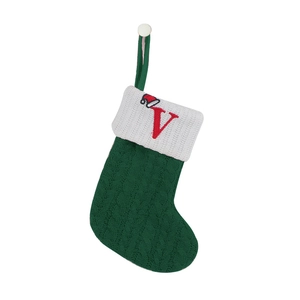 Detail of green knit Christmas stocking with white cuff and red embroidered letter V