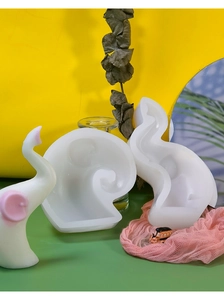 Detailed view of DIY elephant silicone mold with finished resin craft on colorful background