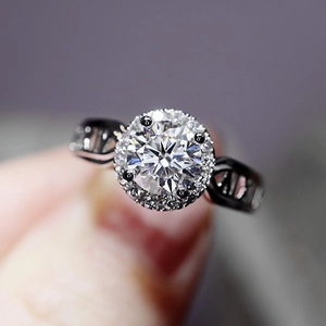 Close-up of sparkling round-cut moissanite ring with halo and roman numeral band