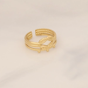 Close-up of golden triple-layered stainless steel ring with knot and bead details