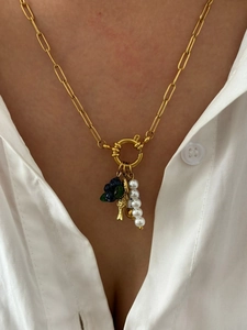 Detailed view of golden paperclip chain necklace with pearls and blue berry charms