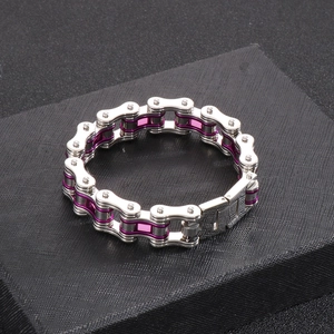 Detail of silver and purple bike chain bracelet on a black textured base