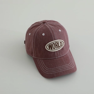 Detailed view of red washed denim baseball cap with white contrast stitching and WORLD patch