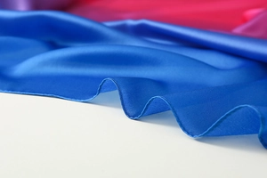 Detailaufnahme des blauen Seidenschal-Stoffs mit glatter Textur und gewellten Kanten