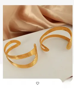 Detail showing the layered golden wavy texture and high-polish finish of the cuff bracelet