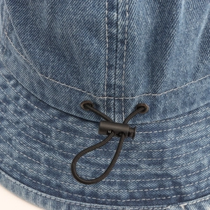 Detail of adjustable black drawstring and plastic buckle on denim sun hat with stitching