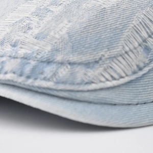 Detail shot of light blue washed denim cap fabric with fine stitching and pattern