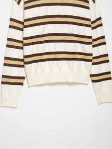 Detail of the soft striped knit sweater showing brown and yellow bands and ribbed cuffs