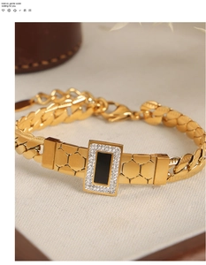 Detail of gold-plated bracelet featuring black enamel centerpiece and pave crystal border