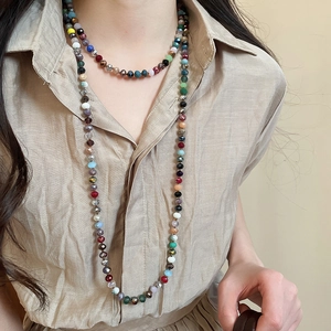 Detail of layered bohemian necklace featuring multi-colored faceted crystal beads on model