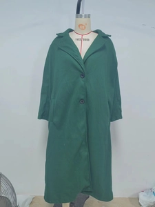 Detail of dark green wool blend trench coat showing lapels and two-button closure