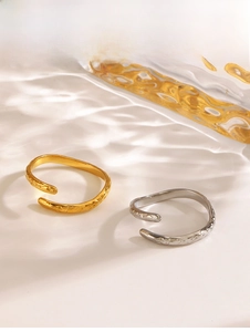 Detailed view of gold and silver hammered texture stackable open rings with water ripple shadows