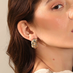 Boucles d'oreilles spirales en acier inoxydable plaqué or 18K portées par un mannequin