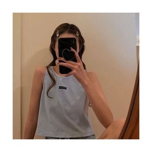 Mirror selfie showing the fit of a light blue sleeveless vest with a black patch detail