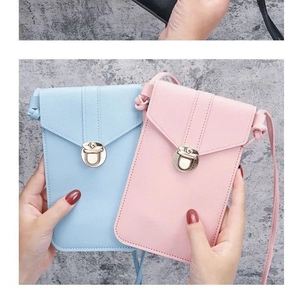 Hand holding mini PU leather crossbody phone bags in light blue and soft pink with gold locks