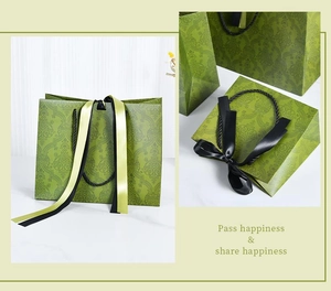 Detail of olive green luxury paper gift bag with embossed texture and gold ribbon bow
