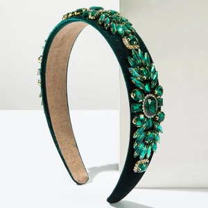 Close-up of dark green velvet headband with floral clusters of emerald and crystal rhinestones