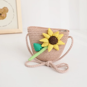 Close-up of children's woven straw bag featuring a vibrant fabric sunflower decoration.