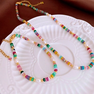 Détail de perles colorées et bracelet de perles d'eau douce sur une assiette élégante