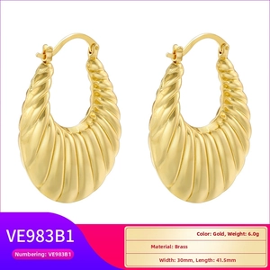 Detailed view of gold plated hollow C-shape earrings with textured 3D pleated finish