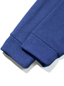 Detail shot of navy blue cotton knit fabric texture and elastic ribbed cuff on the sweatshirt