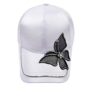 White satin baseball cap with a large black butterfly and iridescent rhinestones on white background
