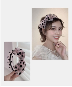 Detail of pink polka dot bow headband showing the soft mesh fabric and styling on model