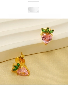 Macro shot of strawberry-shaped heart pink zircon studs on a golden setting