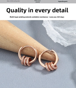 Macro detail of rose gold S925 sterling silver hoop earrings with cubic zirconia charms