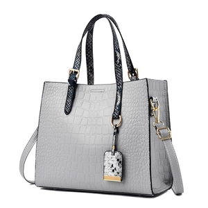 Light gray crocodile embossed tote bag with snakeskin handles and gold metal accents