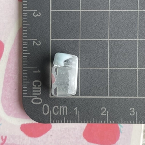 Close-up of a mini transparent juice bottle resin accessory measured on a scale mat
