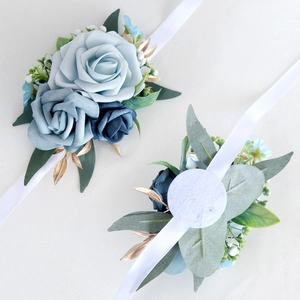 Bridal wrist corsage featuring blue artificial roses with golden leaves and white silk ribbon
