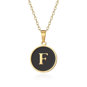 Dettaglio della collana in acciaio dorato con ciondolo circolare in smalto nero e lettera F