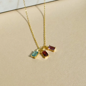 Detail of 18K gold plated steel necklace with blue red and purple zircon pendants
