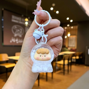 Détail d'un porte-clés astronaute créatif avec casque transparent et clochette blanche